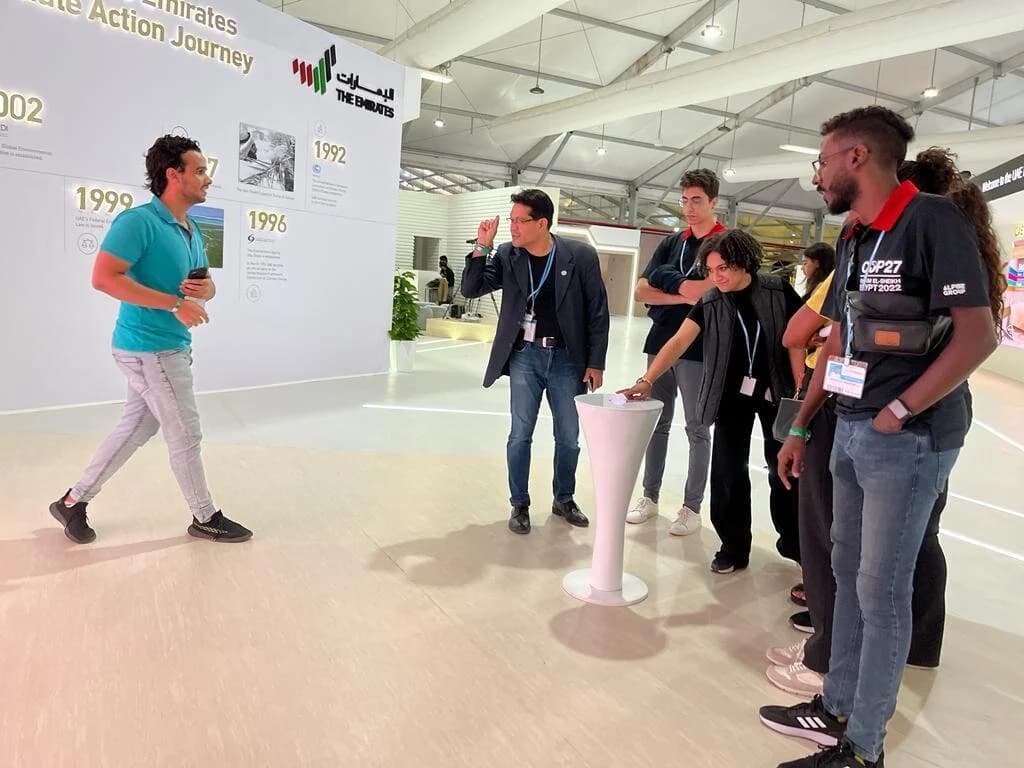 Ibrahim ( Ibra ) Gamal presenting on screen in a professional conference room with team members