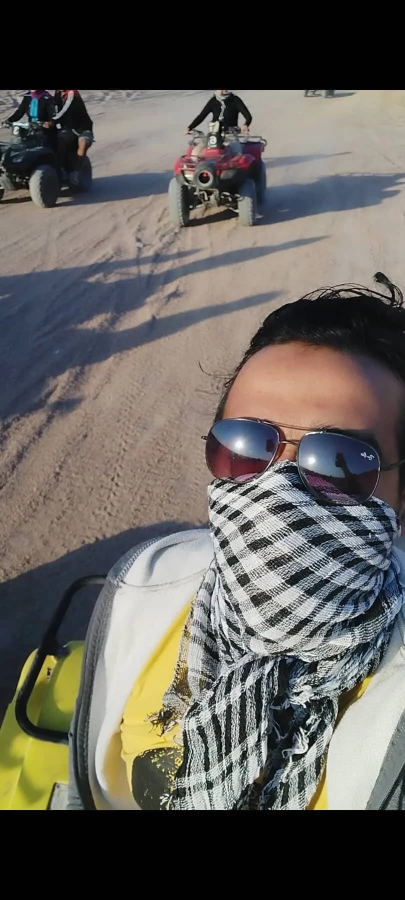 Ibrahim ( Ibra ) Gamal relaxing on sandy desert terrain wearing sunglasses during outdoor adventure